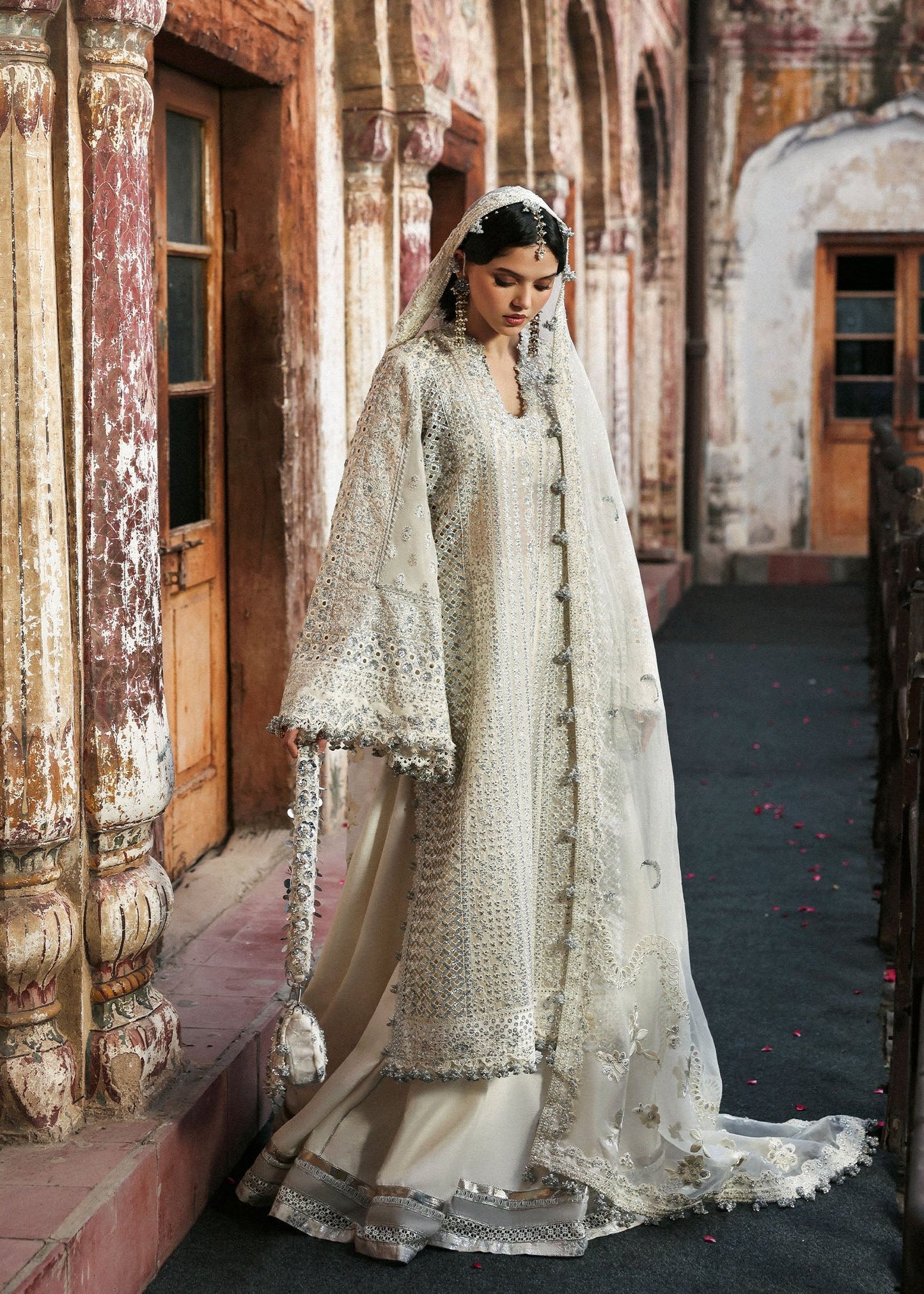 Elegant ivory organza shirt with sequin embroidery, silk sharara, and chiffon dupatta. Unstitched luxury outfit exuding timeless grace and sophistication.