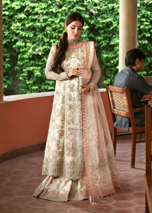 Ethereal ivory frost suit with hand-embellished organza panels, ornate borders, embroidered dupatta, and printed trouser for timeless elegance.