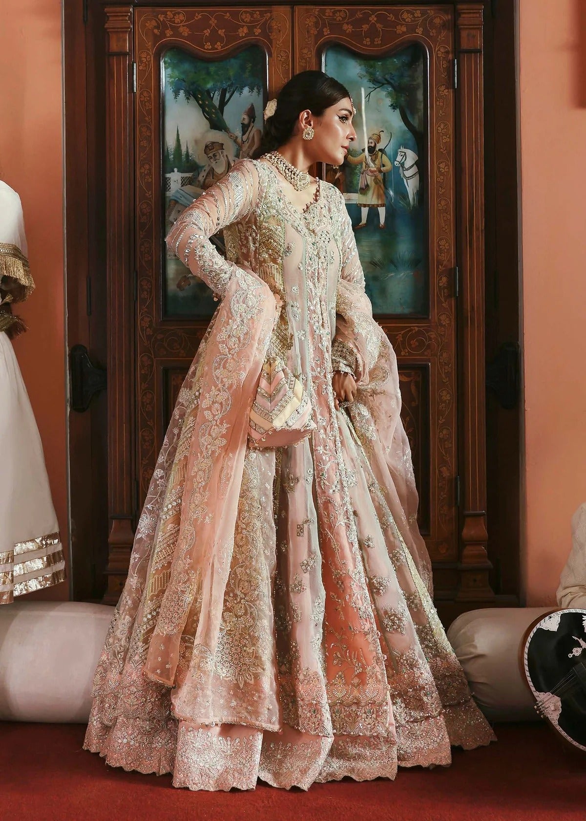 Stunning jewel-toned lehenga suit with hand-embellished shirt, embroidered borders, and organza dupatta for a regal festive look.