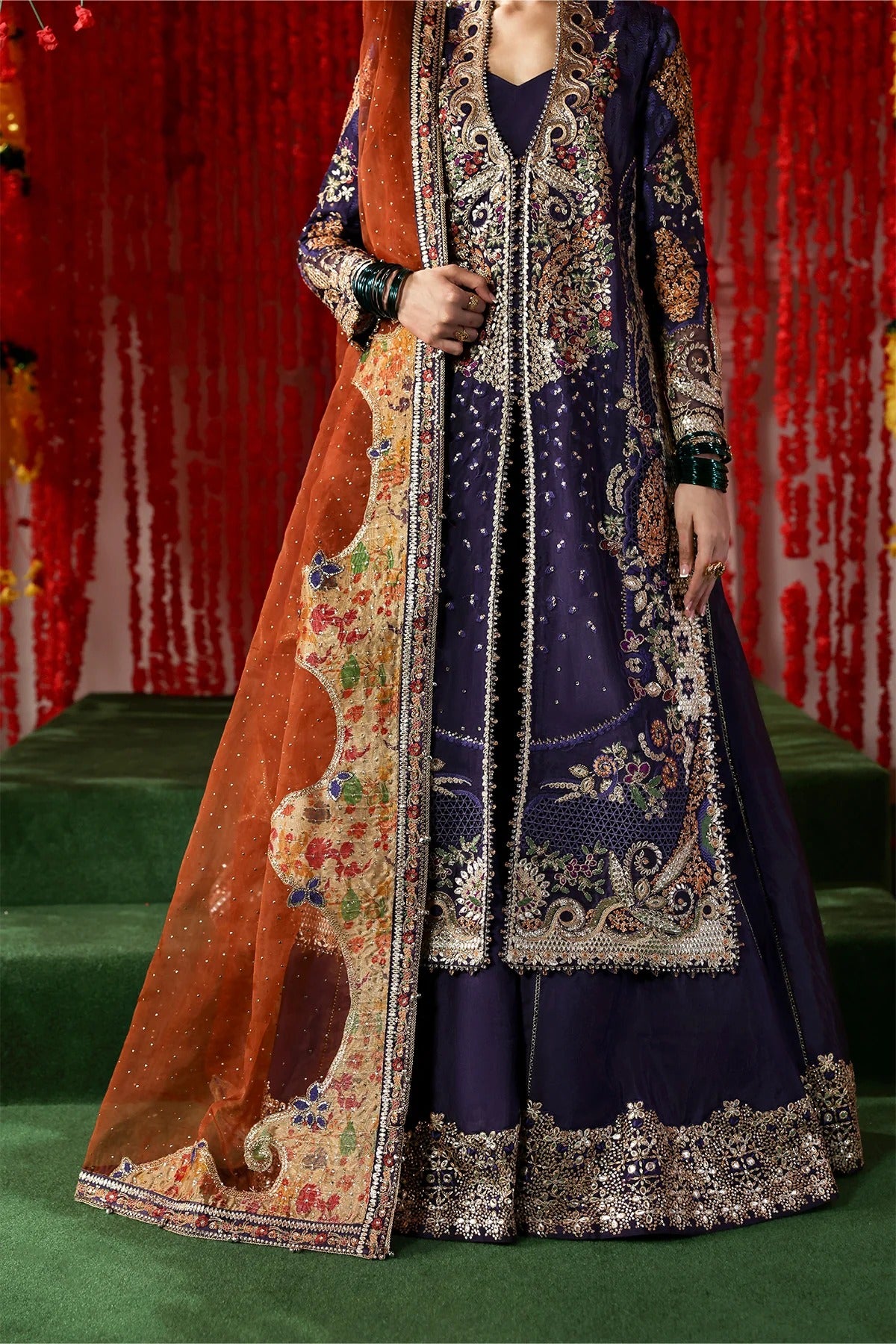 Regal purple raw silk dress with intricate embroidery, rust organza dupatta, and printed tissue zari patches. Ideal for festive and formal occasions.