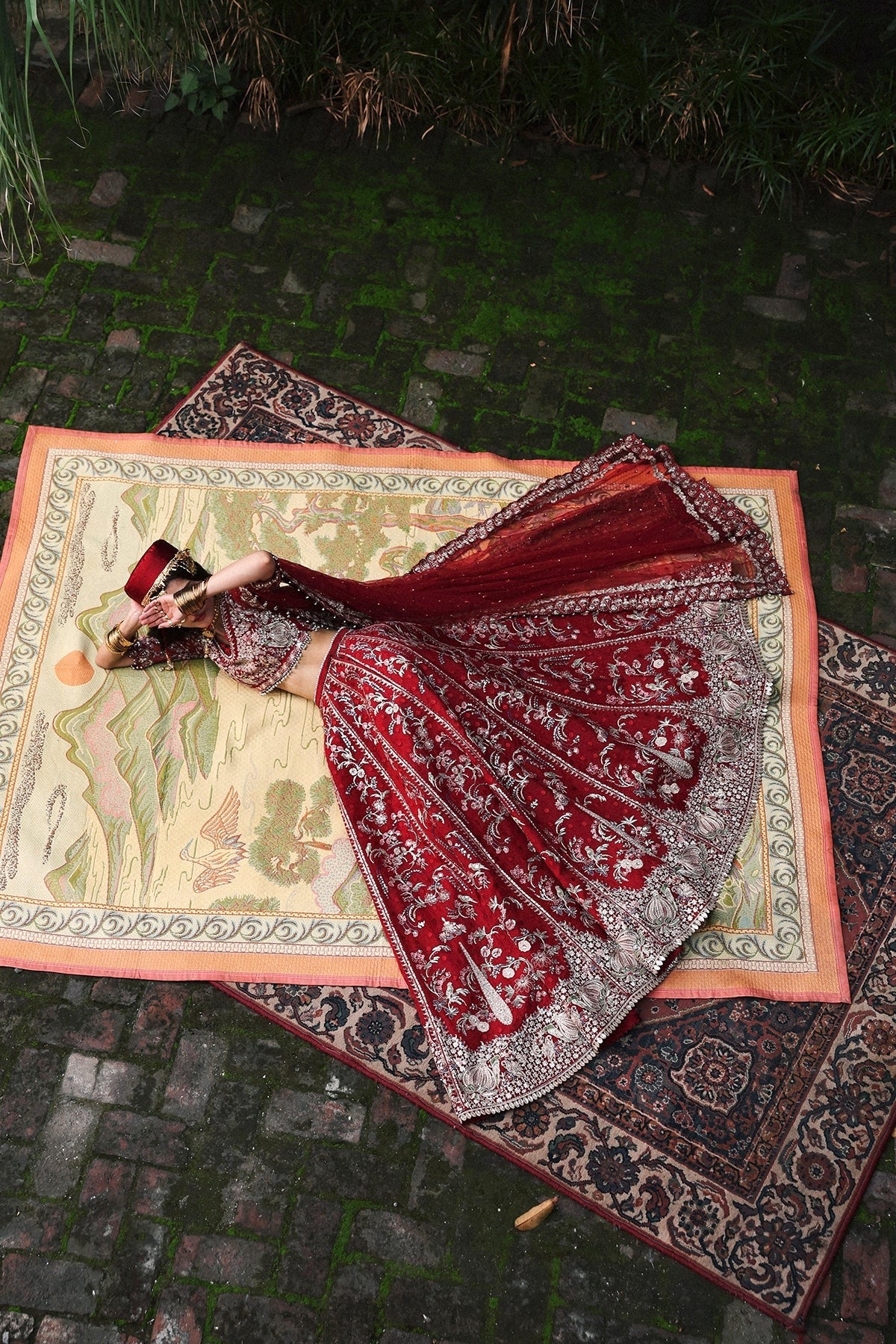 Vibrant red organza and shmoz silk embroidered panels, sleeves, dupatta, and borders paired with raw silk trousers for a bold, elegant custom outfit.