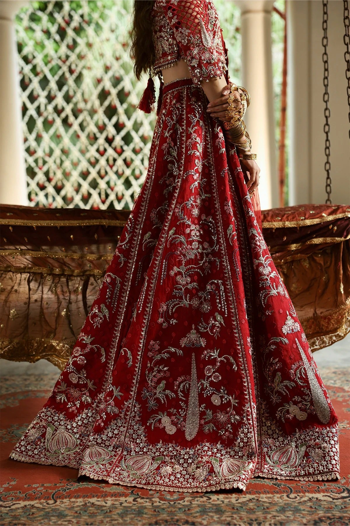 Vibrant red organza and shmoz silk embroidered panels, sleeves, dupatta, and borders paired with raw silk trousers for a bold, elegant custom outfit.