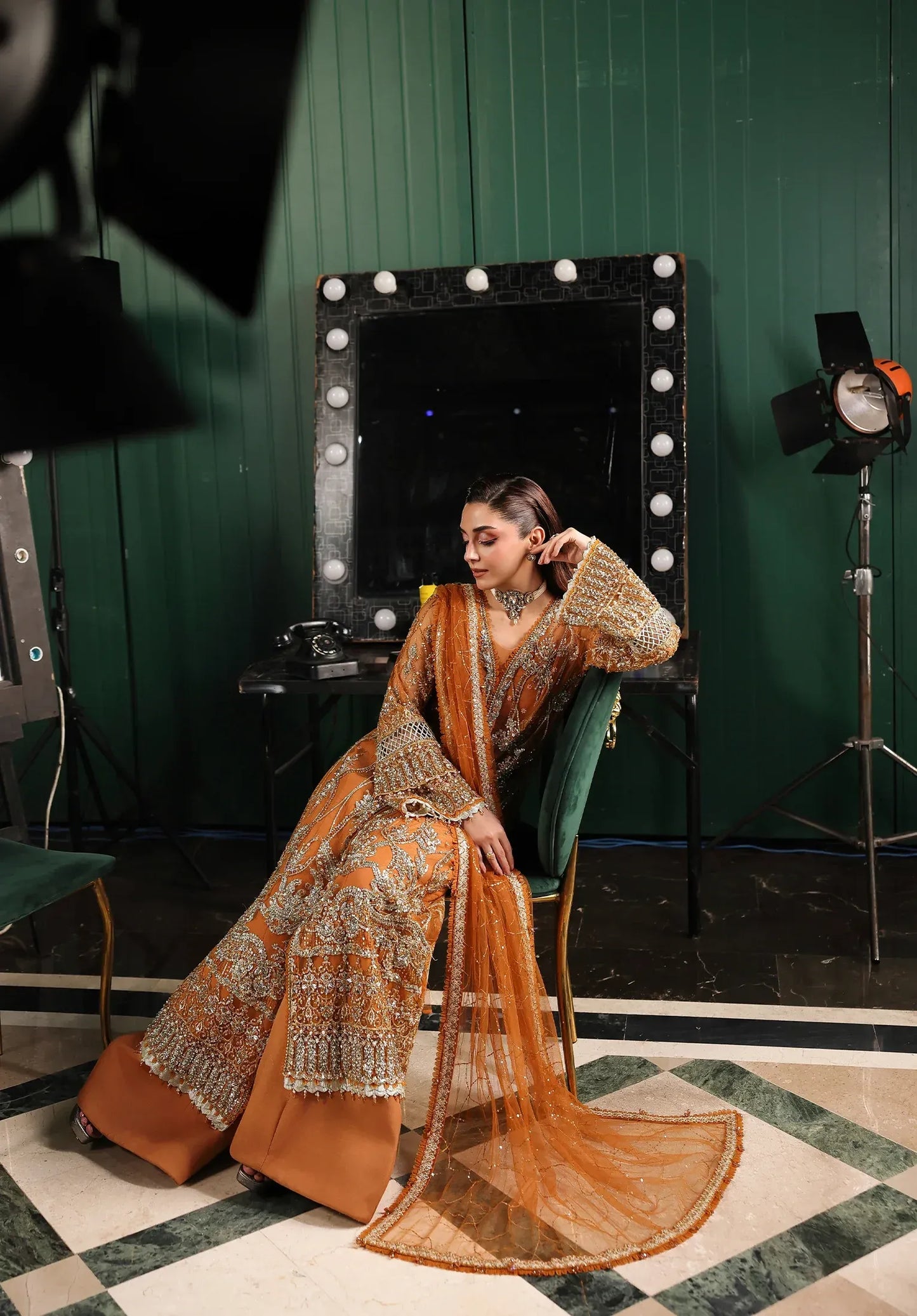 Saffron from Elaf Stardom ’25 features hand-embellished poly-net panels, embroidered dupatta, and raw silk inner — a graceful choice for festive elegance.