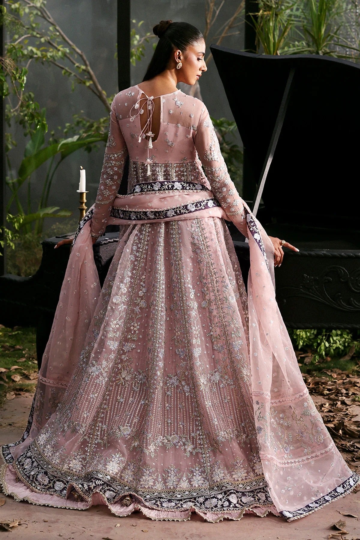 Graceful baby pink organza dress adorned with detailed embroidery and rich purple borders. Includes matching dupatta and trouser. Ideal for festive wear.