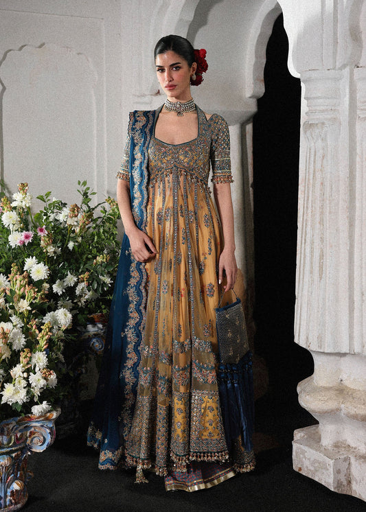 Graceful butter yellow net pishwas with embroidered panels and sleeves, paired with printed Korean raw silk sharara and a chiffon dupatta with borders.