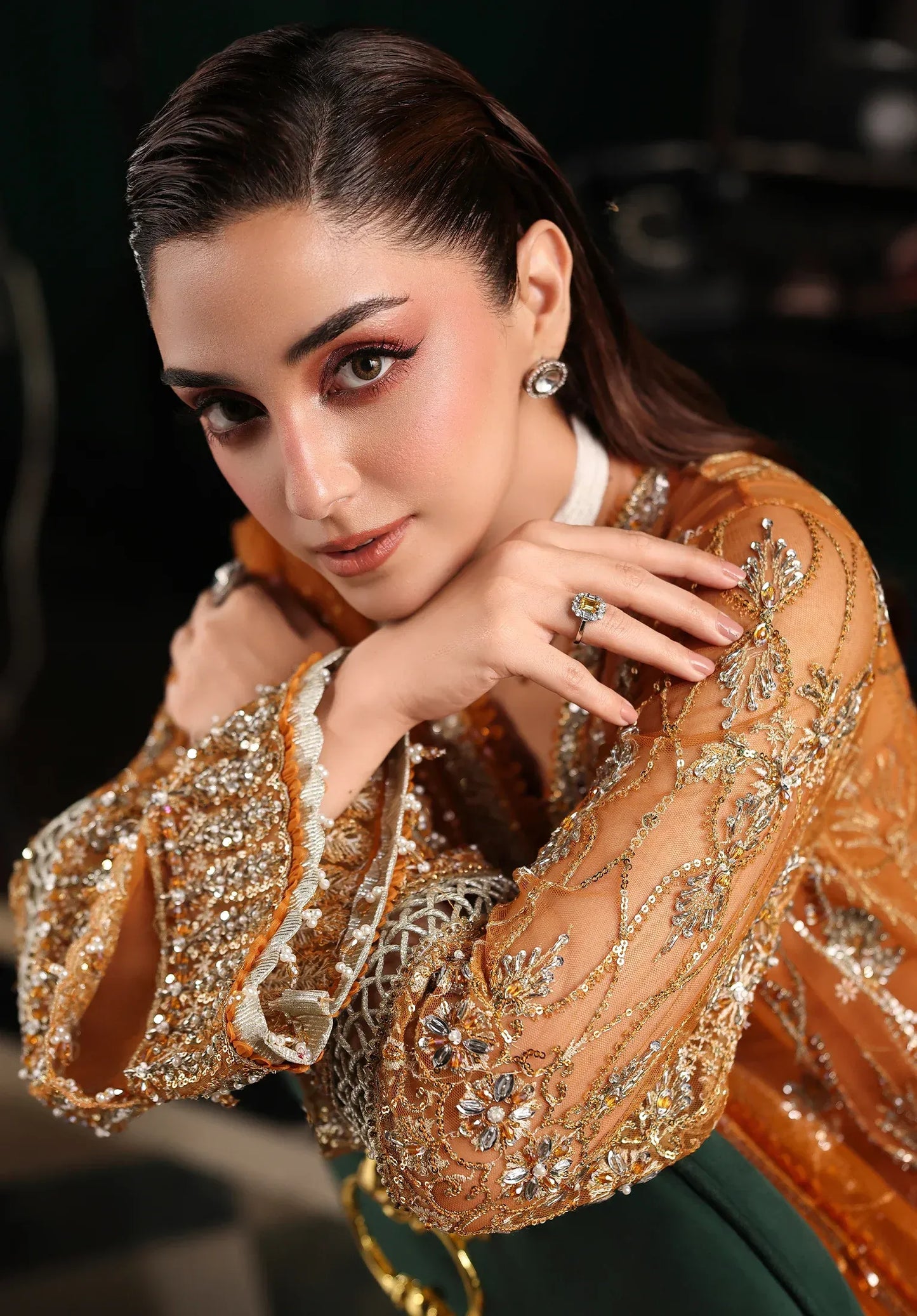 Saffron from Elaf Stardom ’25 features hand-embellished poly-net panels, embroidered dupatta, and raw silk inner — a graceful choice for festive elegance.