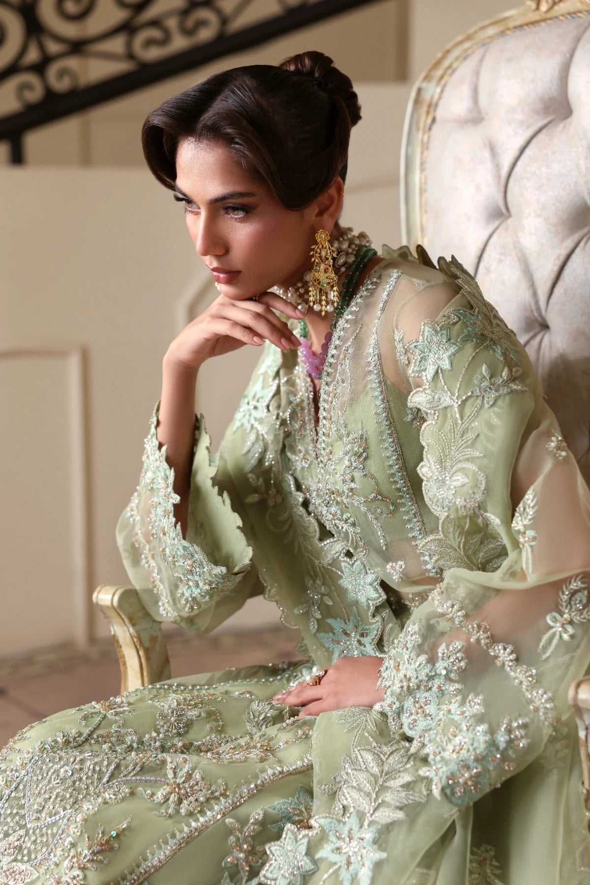 Luxurious organza suit featuring hand-embellished panels, sleeves, borders, and dupatta. Paired with Russian grip inner and 4 yards of raw silk trouser fabric.