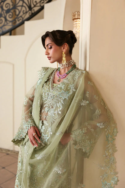 Luxurious organza suit featuring hand-embellished panels, sleeves, borders, and dupatta. Paired with Russian grip inner and 4 yards of raw silk trouser fabric.