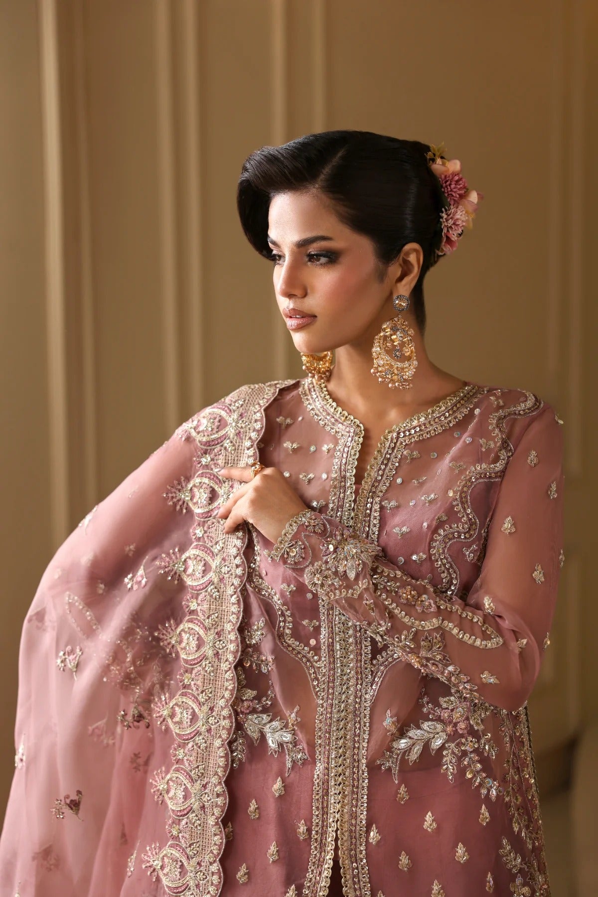 Elegant organza dress featuring hand-embellished panels, sleeves, chok patti, borders, and dupatta. Includes Russian grip inner and raw silk trouser fabric.