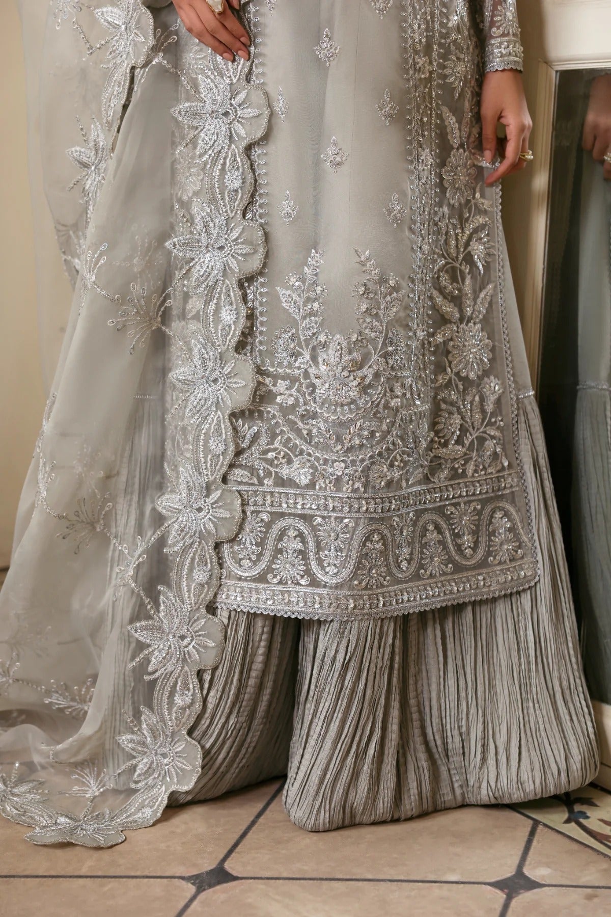 Elegant organza outfit with hand-embellished front, sleeves, and borders. Comes with embroidered dupatta, Russian grip inner, and 6 yards of raw silk trouser.