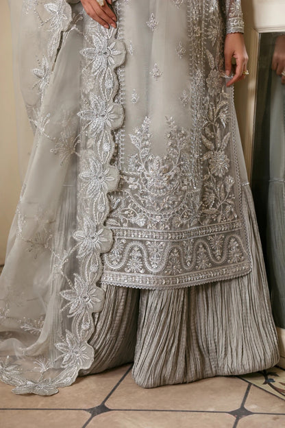 Elegant organza outfit with hand-embellished front, sleeves, and borders. Comes with embroidered dupatta, Russian grip inner, and 6 yards of raw silk trouser.