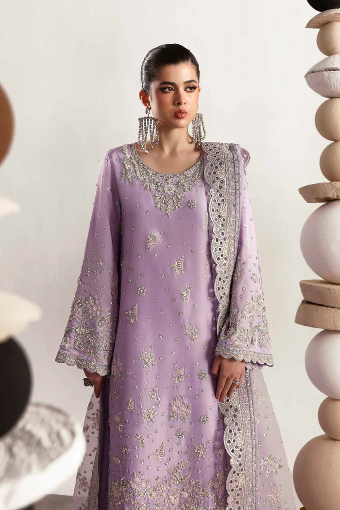 Premium silk suit featuring hand-embellished front and neckline, embroidered sleeves and borders, dyed silk back, matching trouser, and organza dupatta.