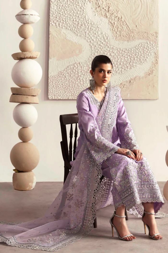 Premium silk suit featuring hand-embellished front and neckline, embroidered sleeves and borders, dyed silk back, matching trouser, and organza dupatta.