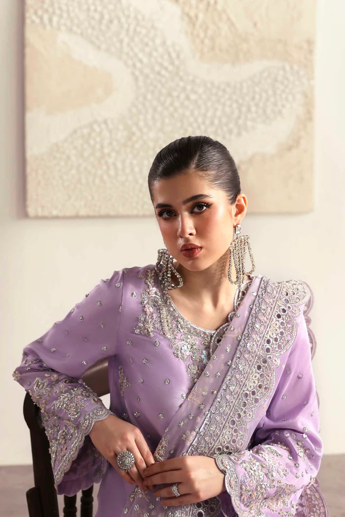 Premium silk suit featuring hand-embellished front and neckline, embroidered sleeves and borders, dyed silk back, matching trouser, and organza dupatta.