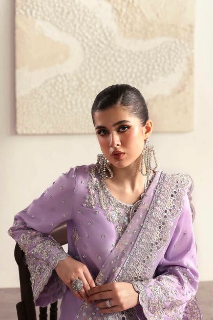 Premium silk suit featuring hand-embellished front and neckline, embroidered sleeves and borders, dyed silk back, matching trouser, and organza dupatta.