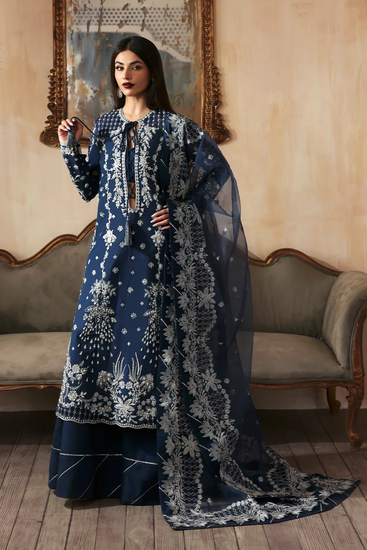 Luxury hand-embroidered raw silk suit with detailed front, back, and sleeves panels, paired with an elegant organza dupatta and matching dyed silk trousers—perfect for festive occasions.
