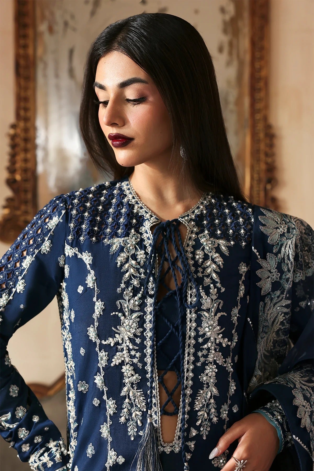 Luxury hand-embroidered raw silk suit with detailed front, back, and sleeves panels, paired with an elegant organza dupatta and matching dyed silk trousers—perfect for festive occasions.