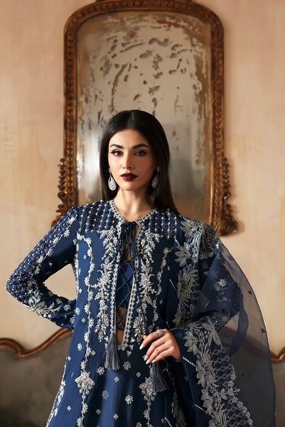 Luxury hand-embroidered raw silk suit with detailed front, back, and sleeves panels, paired with an elegant organza dupatta and matching dyed silk trousers—perfect for festive occasions.