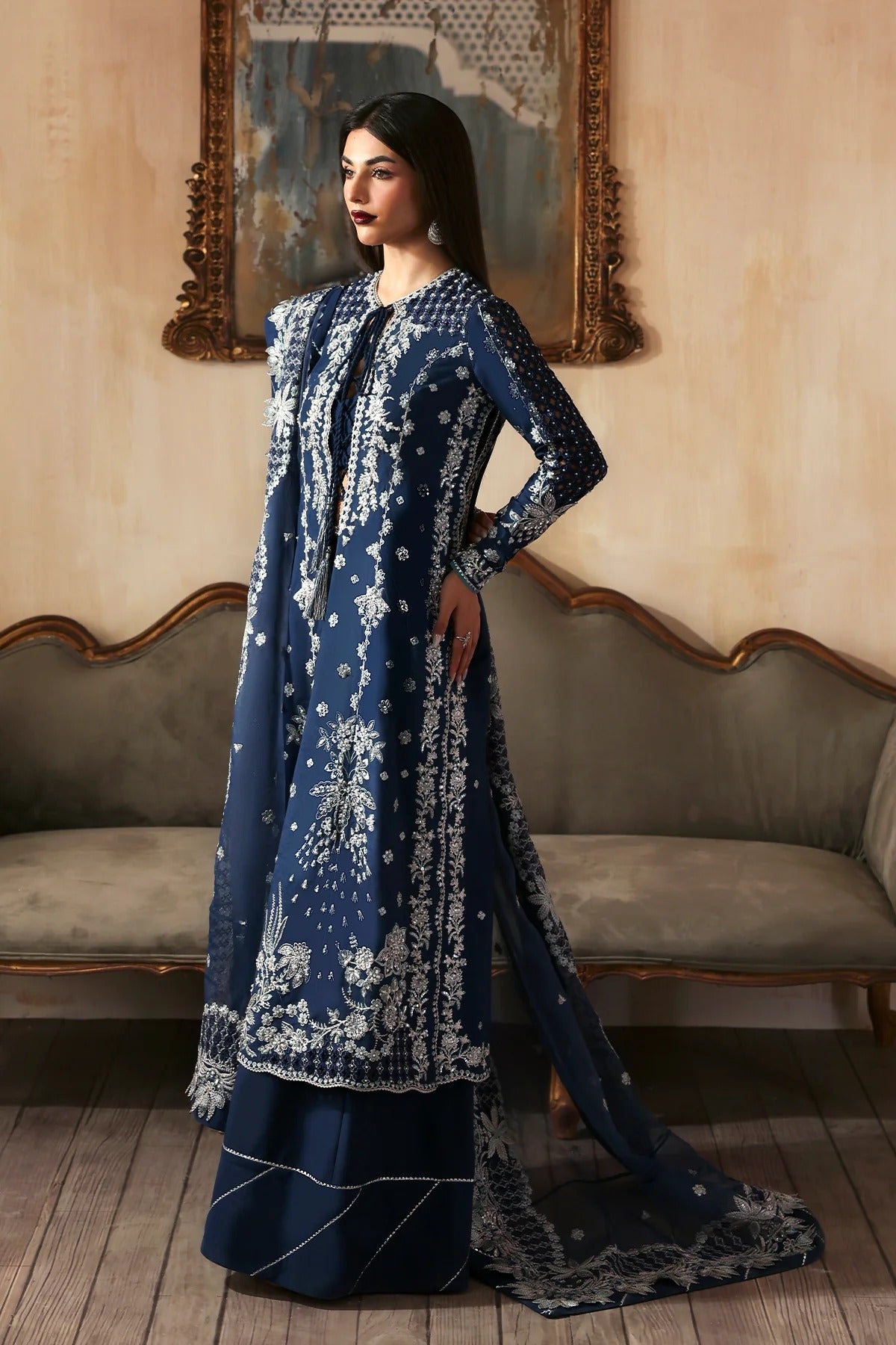 Luxury hand-embroidered raw silk suit with detailed front, back, and sleeves panels, paired with an elegant organza dupatta and matching dyed silk trousers—perfect for festive occasions.