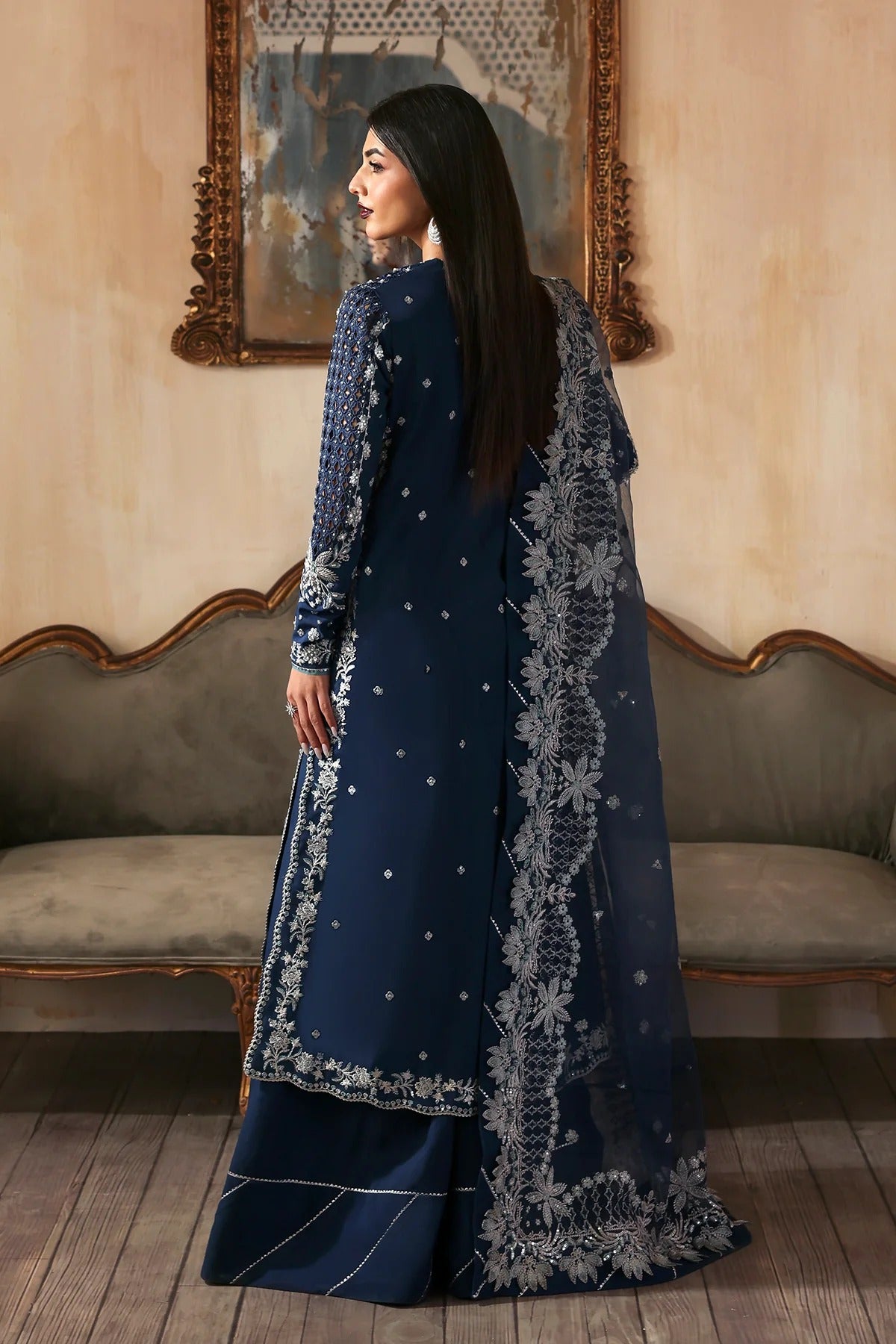Luxury hand-embroidered raw silk suit with detailed front, back, and sleeves panels, paired with an elegant organza dupatta and matching dyed silk trousers—perfect for festive occasions.