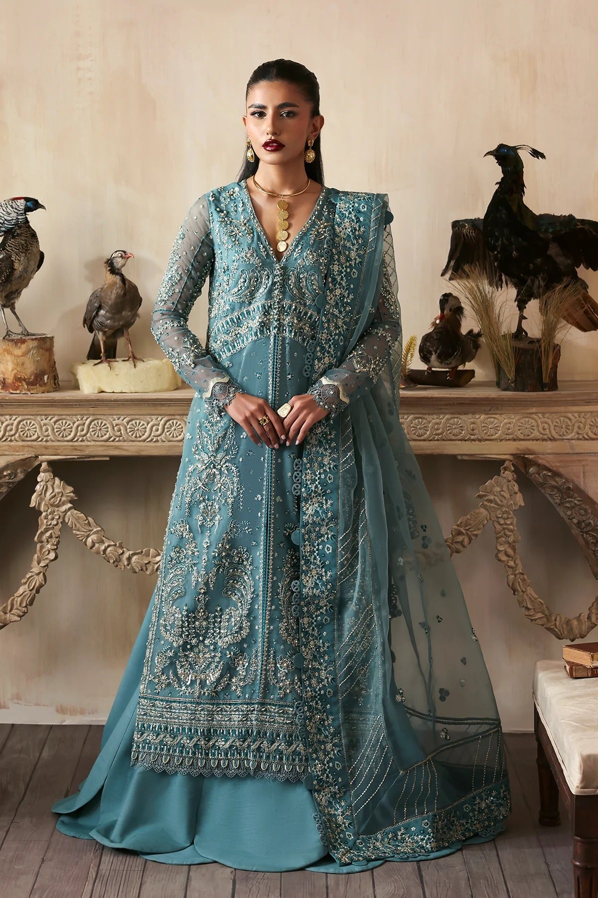 Elegant hand-embroidered organza suit with detailed front, back, and sleeves panels, paired with an embroidered organza dupatta and dyed trousers—perfect for festive occasions.