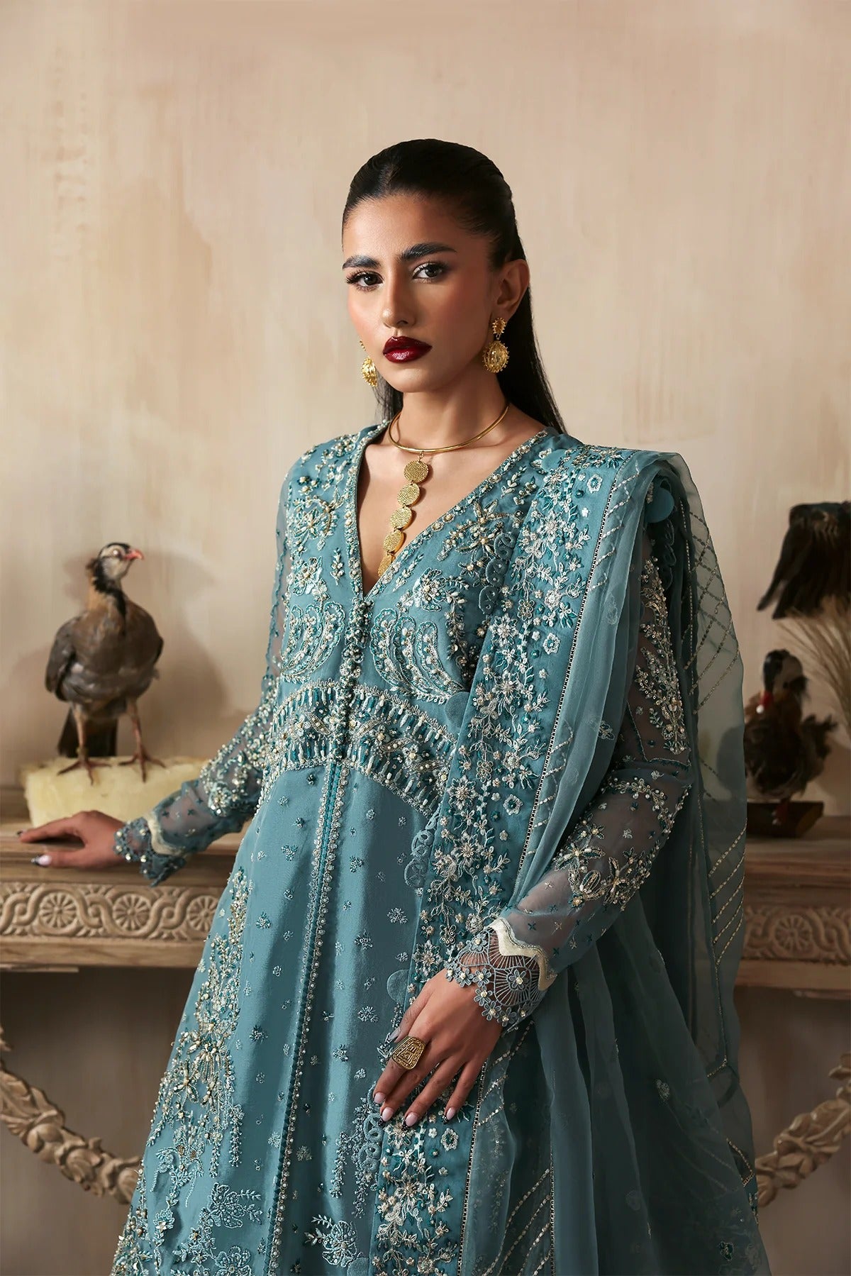 Elegant hand-embroidered organza suit with detailed front, back, and sleeves panels, paired with an embroidered organza dupatta and dyed trousers—perfect for festive occasions.