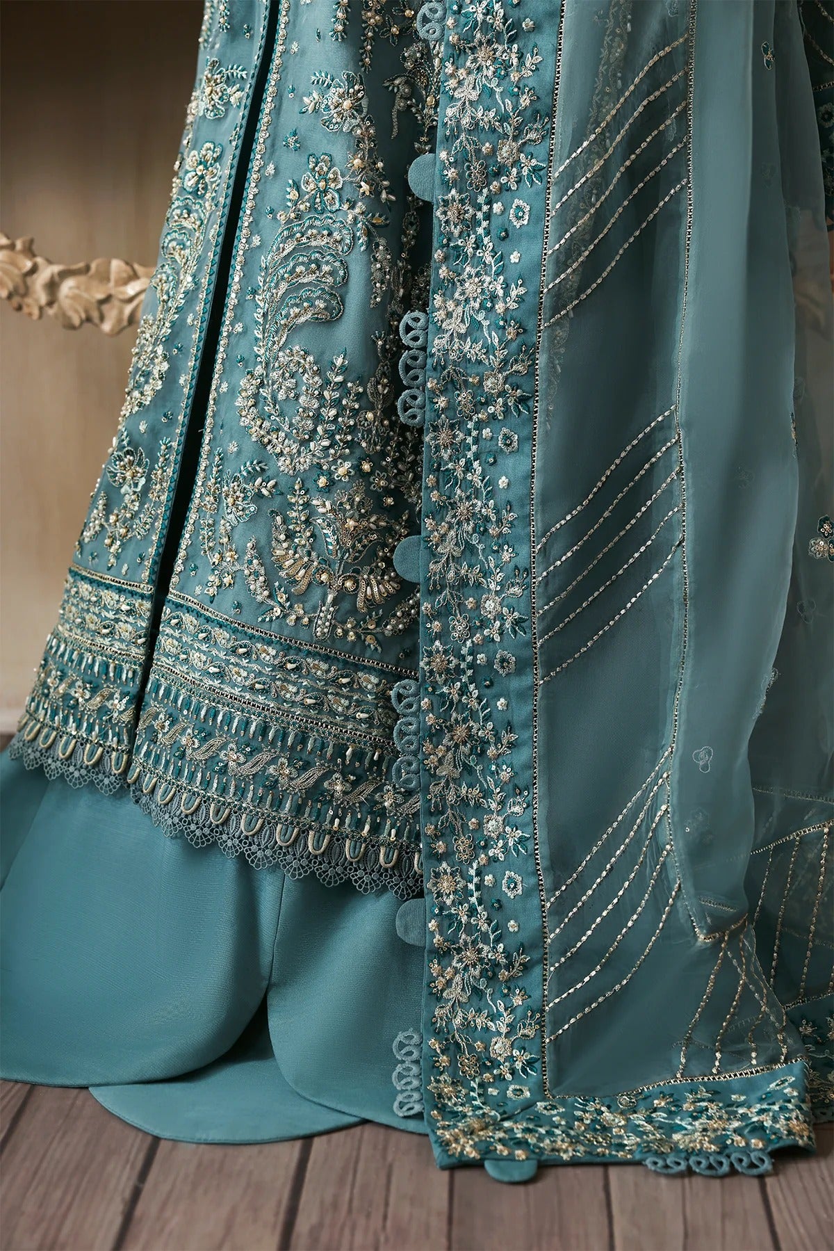 Elegant hand-embroidered organza suit with detailed front, back, and sleeves panels, paired with an embroidered organza dupatta and dyed trousers—perfect for festive occasions.
