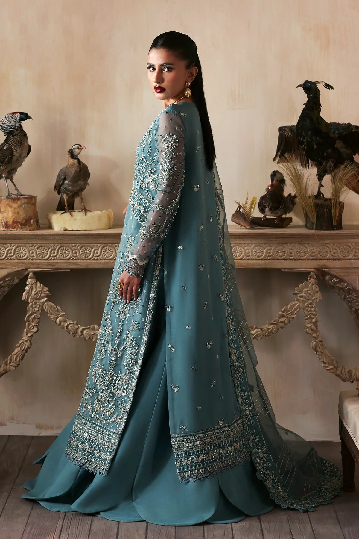 Elegant hand-embroidered organza suit with detailed front, back, and sleeves panels, paired with an embroidered organza dupatta and dyed trousers—perfect for festive occasions.