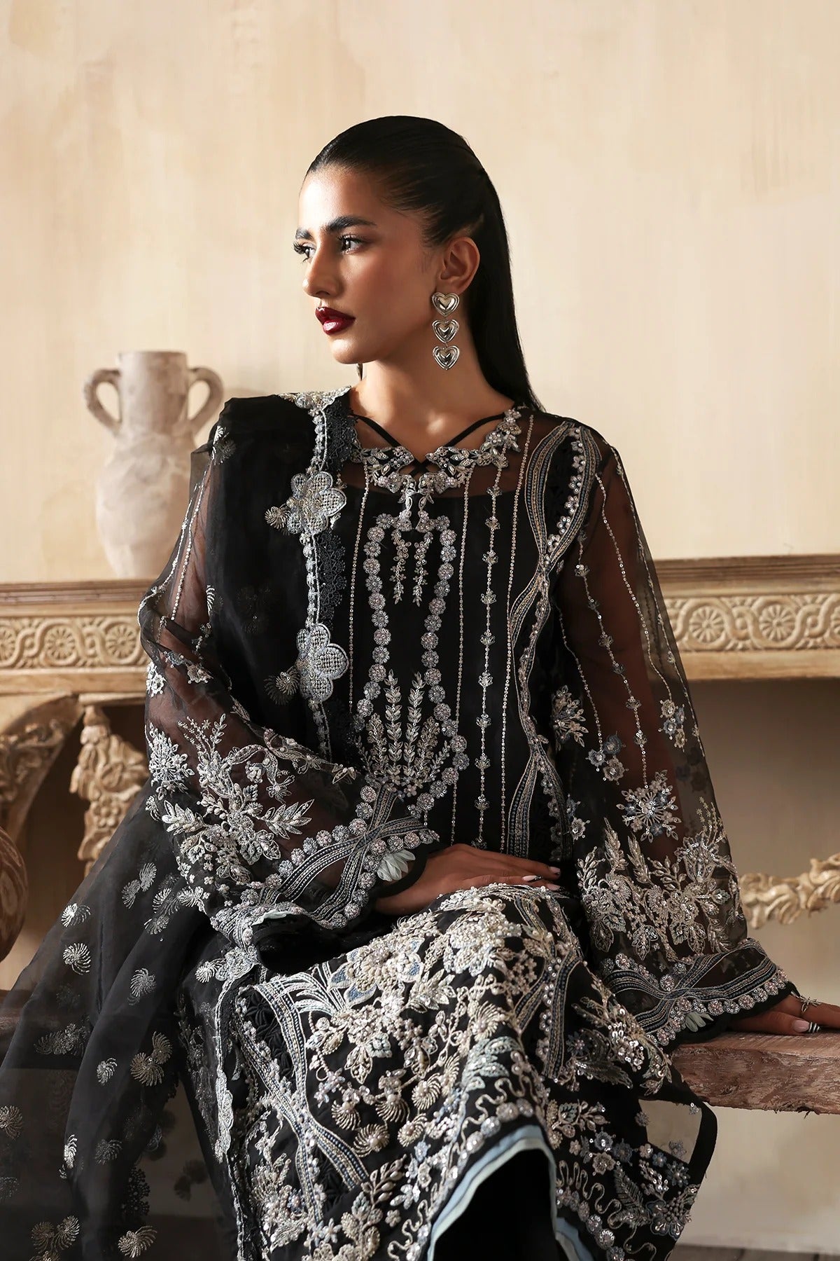 Elegant hand-embroidered organza suit with detailed front, back, and sleeves panels, paired with a matching organza dupatta and dyed trousers—perfect for festive occasions.