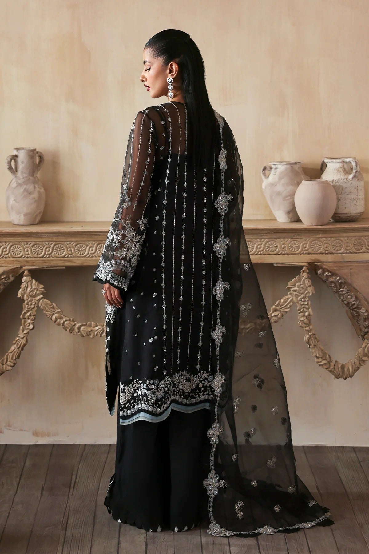 Elegant hand-embroidered organza suit with detailed front, back, and sleeves panels, paired with a matching organza dupatta and dyed trousers—perfect for festive occasions.