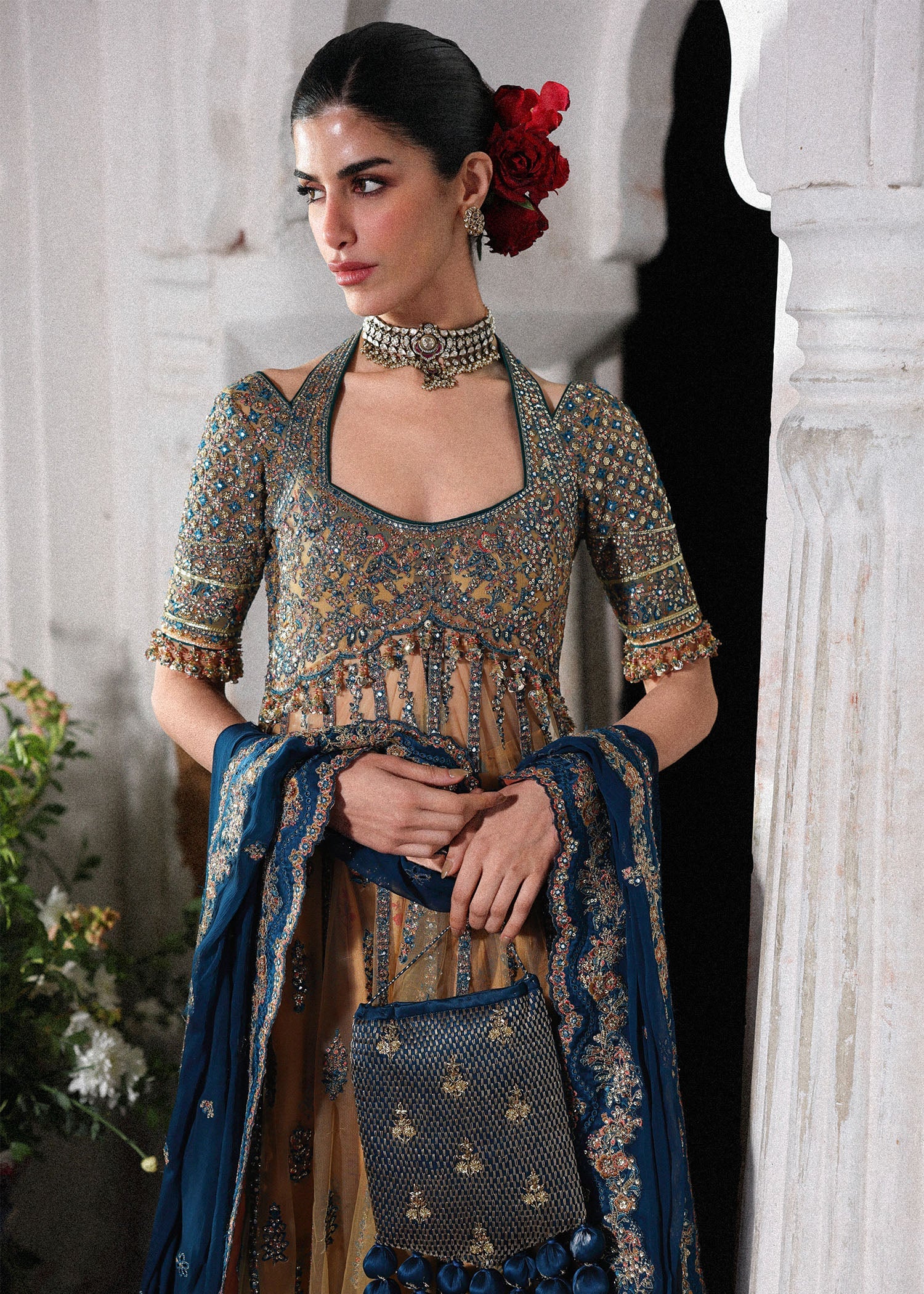 Graceful butter yellow net pishwas with embroidered panels and sleeves, paired with printed Korean raw silk sharara and a chiffon dupatta with borders.