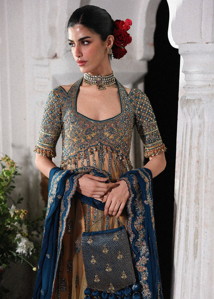 Graceful butter yellow net pishwas with embroidered panels and sleeves, paired with printed Korean raw silk sharara and a chiffon dupatta with borders.