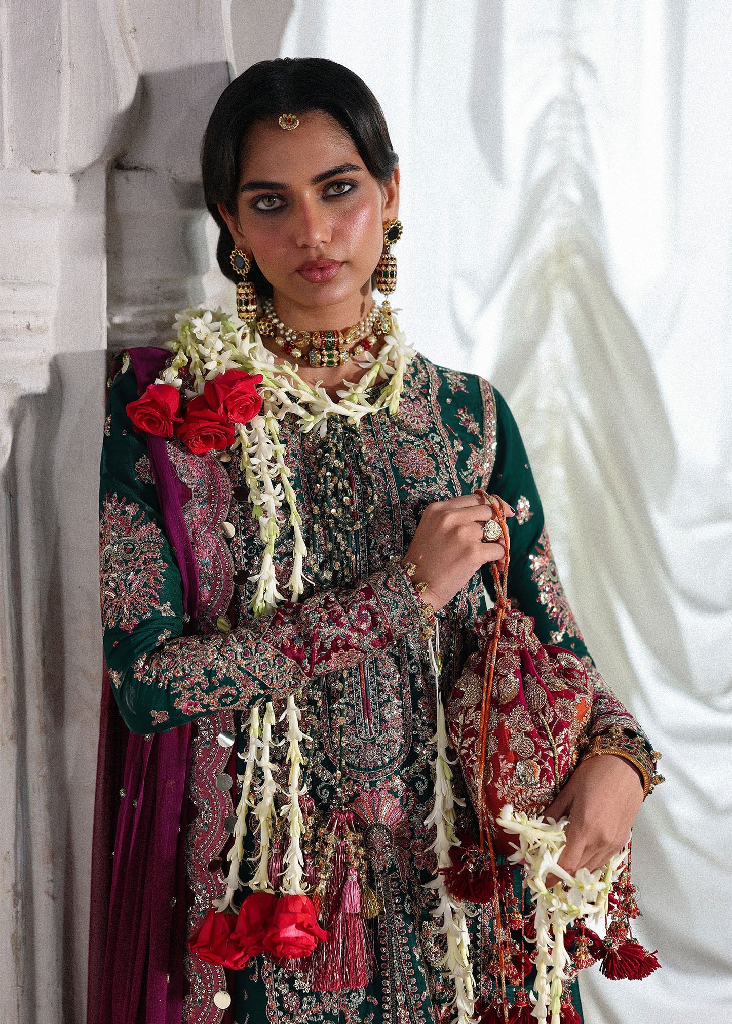 Elegant emerald green Korean raw silk suit with five panel embroidered shirt, printed chooridar and a chiffon dupatta featuring pallu and four sided borders.