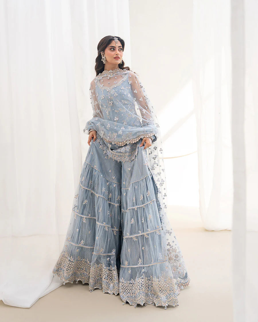 Elegant Oya gharara set in ice blue featuring intricately embroidered net shirt, gharara, and dupatta. Perfect for festive occasions and contemporary celebrations.