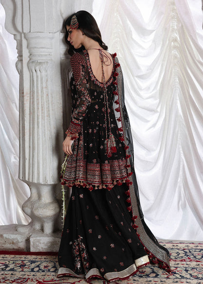 Elegant black embroidered peplum paired with flared Korean raw silk sharara and chiffon dupatta featuring delicate embroidery and four-sided borders for festive events.