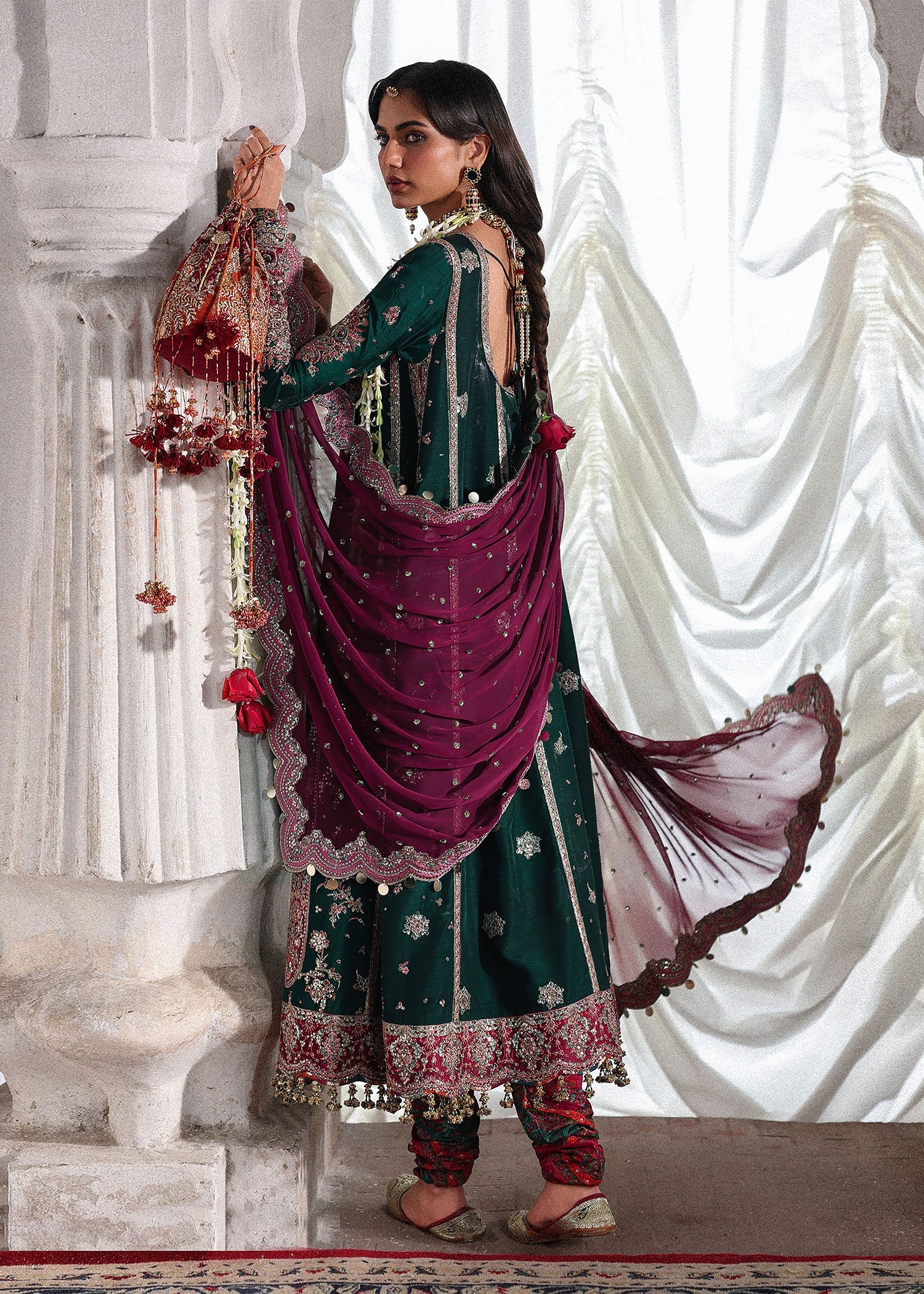 Elegant emerald green Korean raw silk suit with five panel embroidered shirt, printed chooridar and a chiffon dupatta featuring pallu and four sided borders.