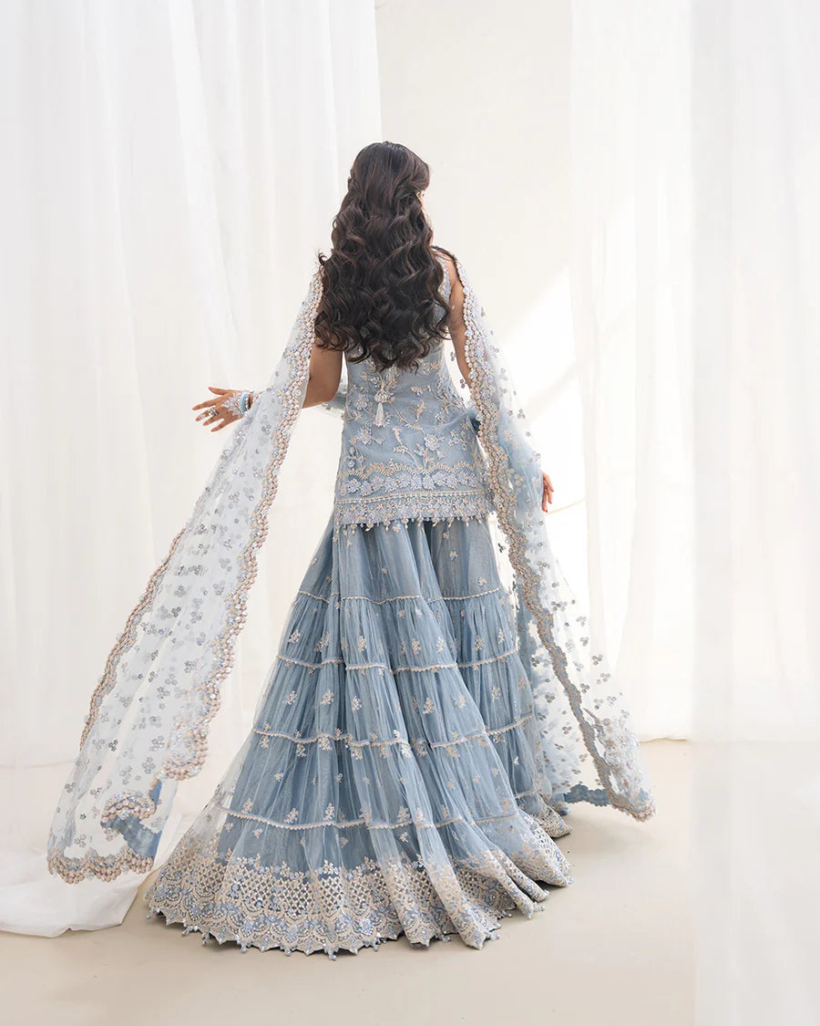 Elegant Oya gharara set in ice blue featuring intricately embroidered net shirt, gharara, and dupatta. Perfect for festive occasions and contemporary celebrations.