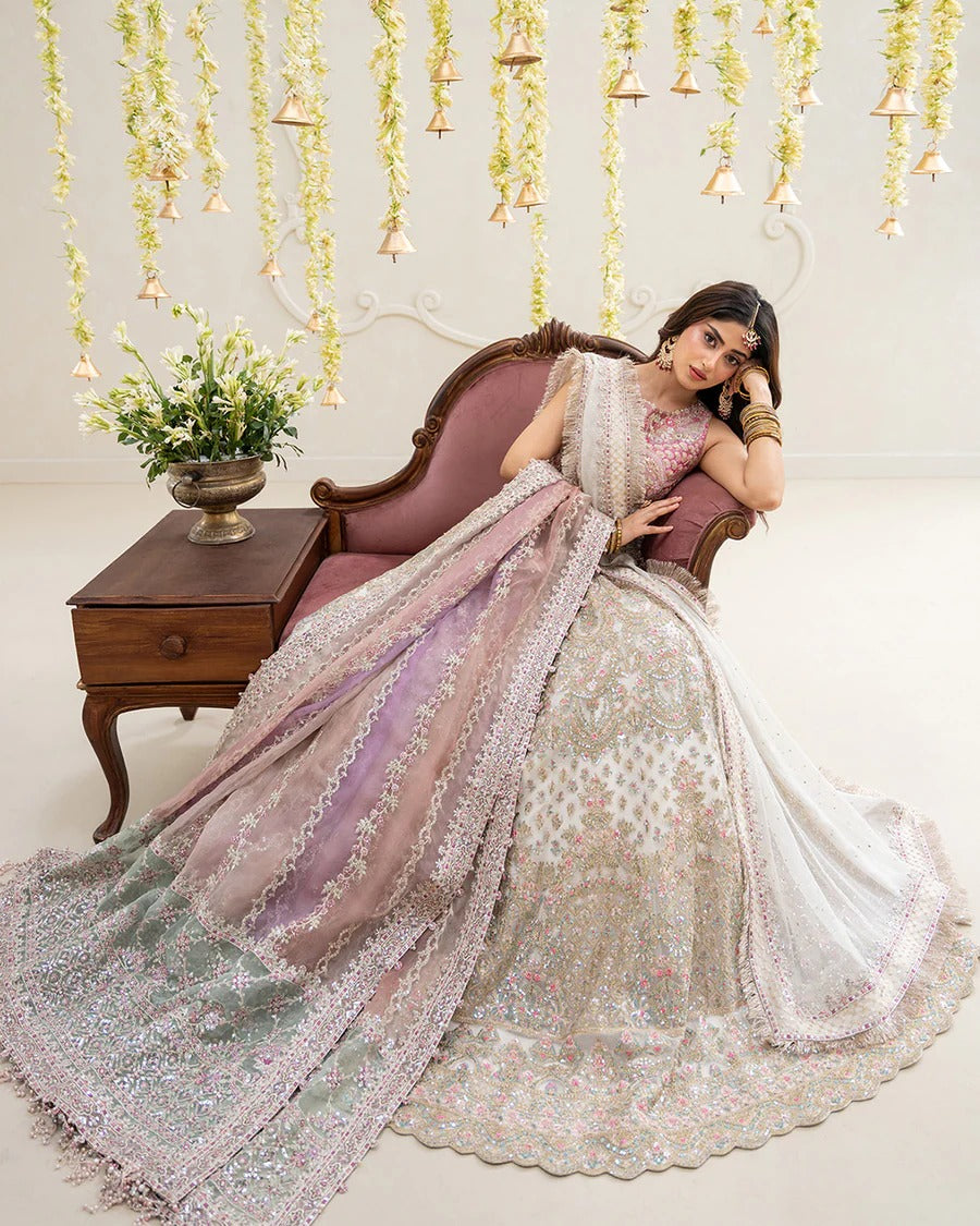 Elegant Suzan lehnga set in blush pink featuring a delicately embroidered tissue blouse, voluminous net skirt, and contrasting organza dupatta—perfect for festive occasions.