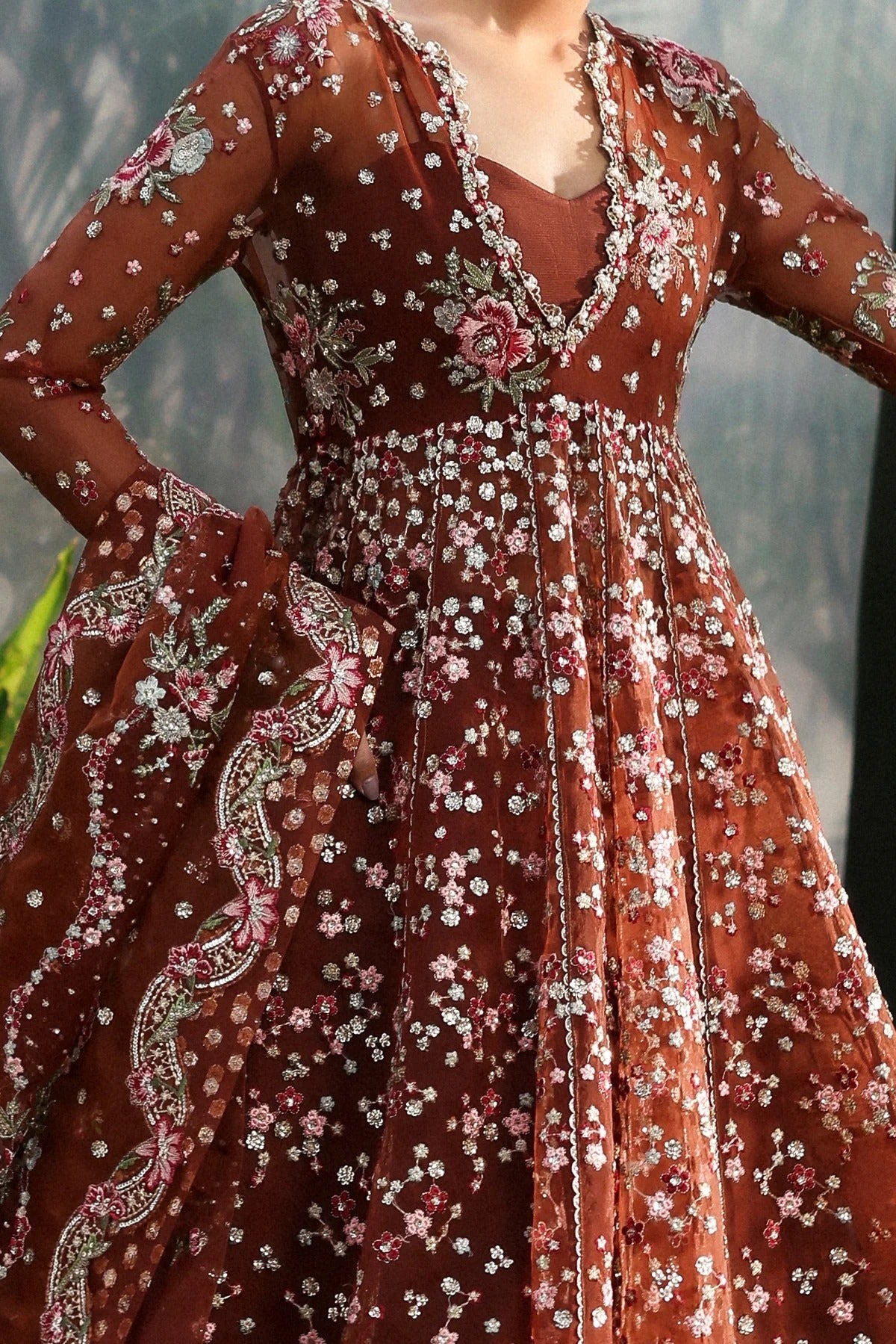 Beautiful rust organza dress featuring detailed embroidery, matching dupatta with pallus, and dyed trouser. Perfect for festive occasions and formal events.