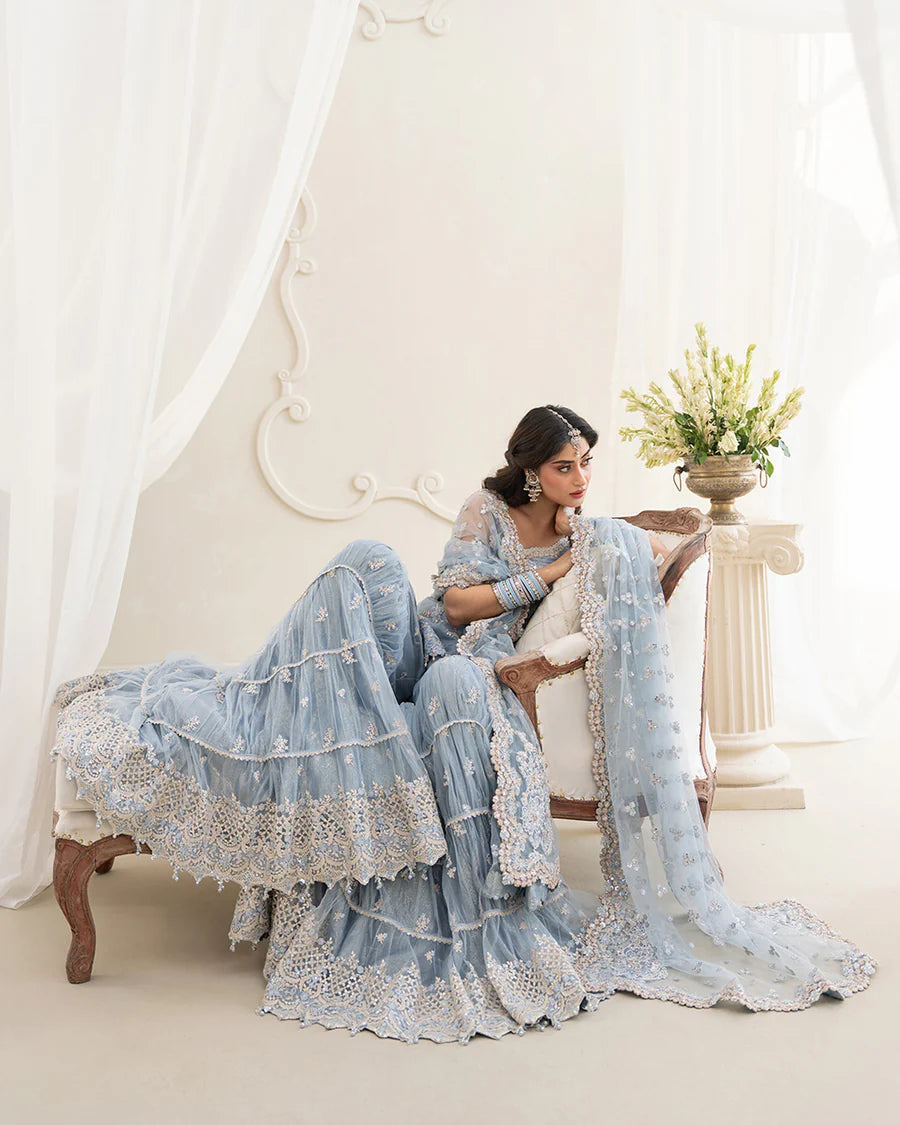 Elegant Oya gharara set in ice blue featuring intricately embroidered net shirt, gharara, and dupatta. Perfect for festive occasions and contemporary celebrations.