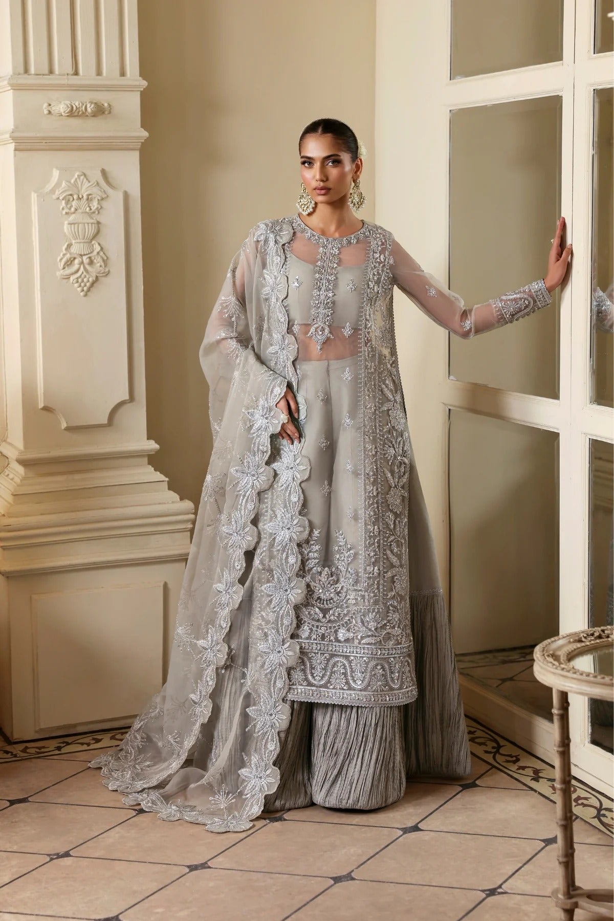 Elegant organza outfit with hand-embellished front, sleeves, and borders. Comes with embroidered dupatta, Russian grip inner, and 6 yards of raw silk trouser.