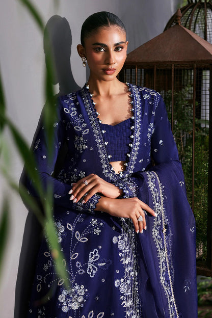 Elegant blue raw silk dress featuring intricate embroidery, organza dupatta, shmoze silk borders, and dyed trousers. Perfect for festive or formal wear.