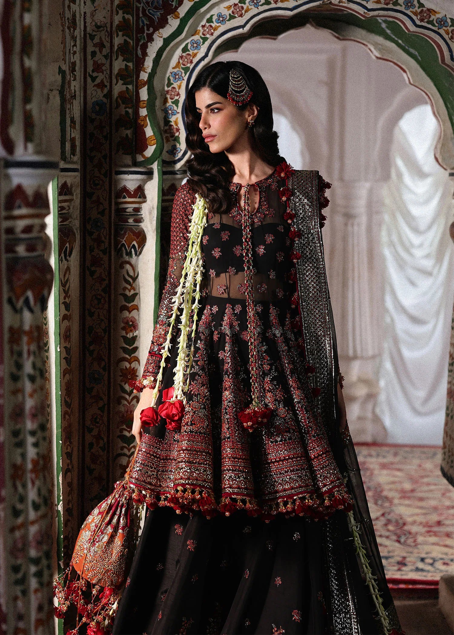 Elegant black embroidered peplum paired with flared Korean raw silk sharara and chiffon dupatta featuring delicate embroidery and four-sided borders for festive events.