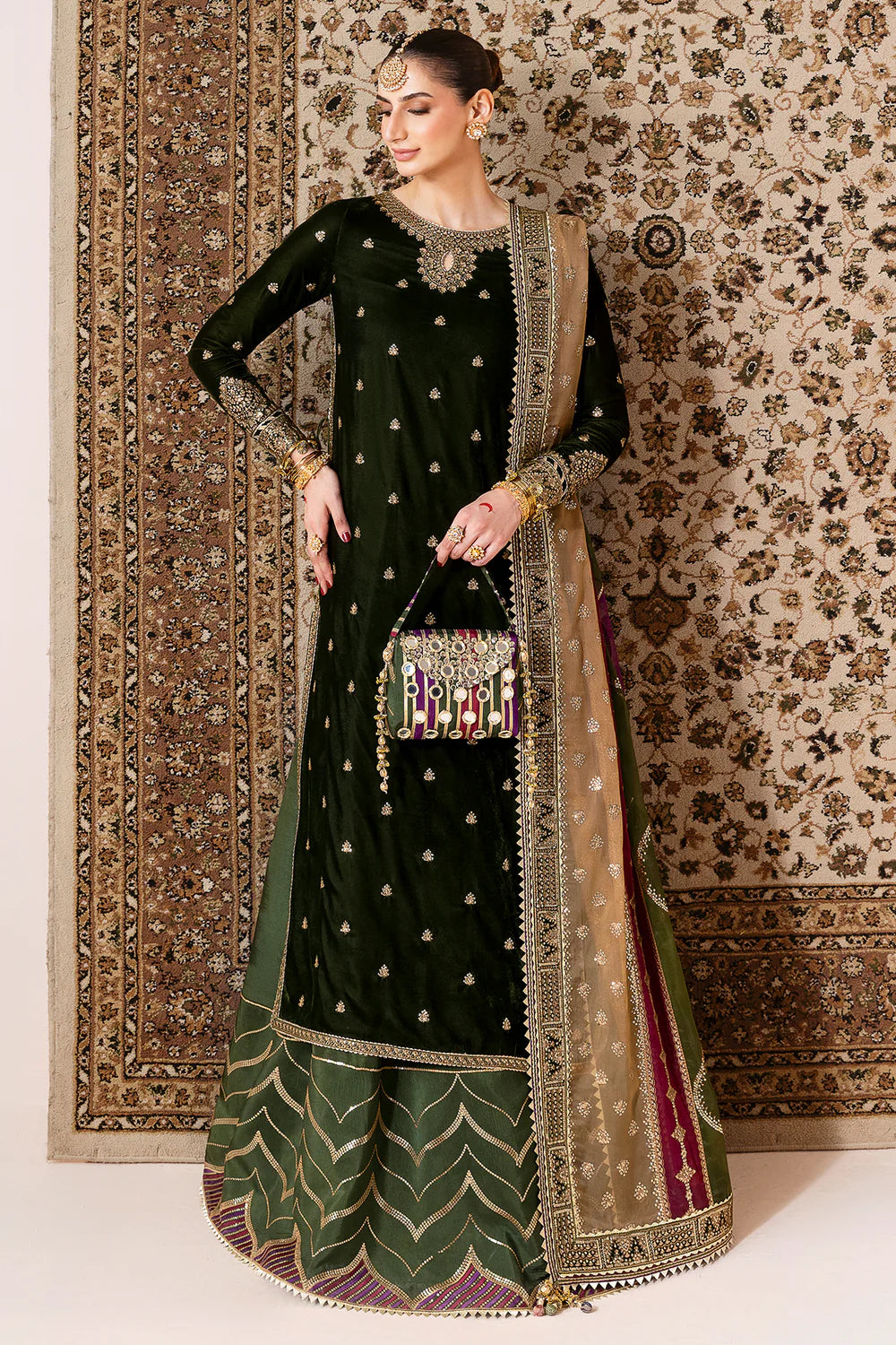 Luxurious velvet suit with intricate embroidery, dyed raw silk bottom, and embroidered organza dupatta. Perfect for formal occasions with timeless elegance.