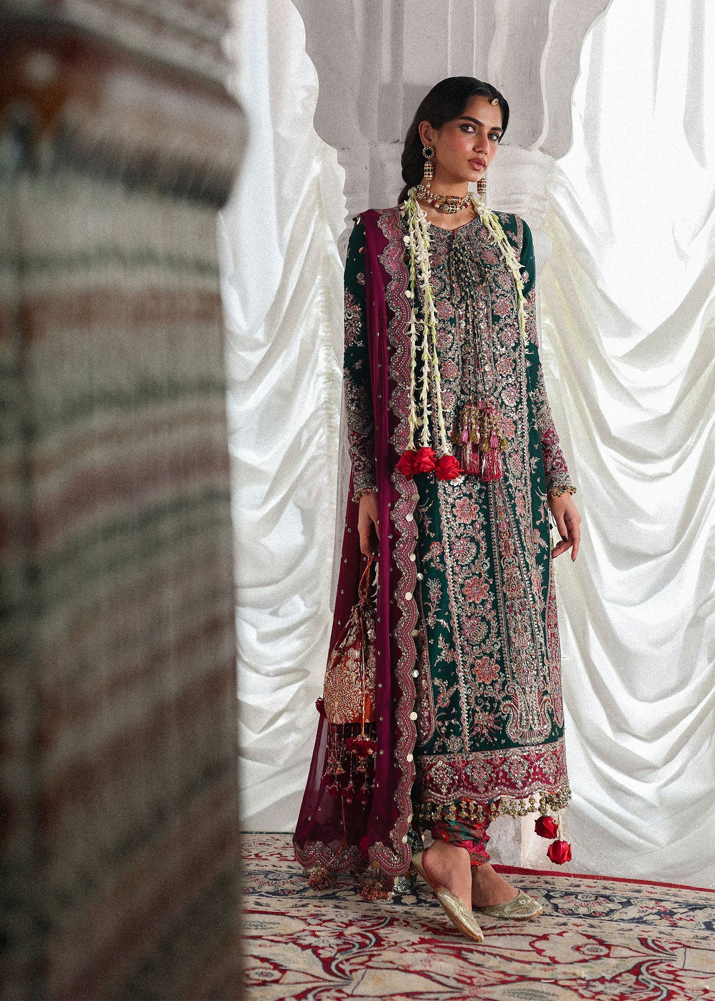 Elegant emerald green Korean raw silk suit with five panel embroidered shirt, printed chooridar and a chiffon dupatta featuring pallu and four sided borders.