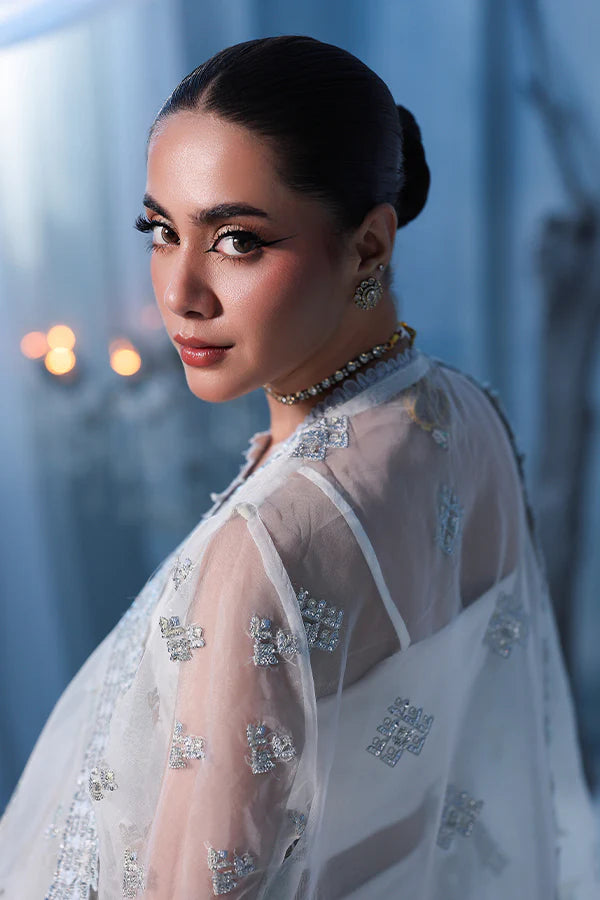 Off-white ivory organza unstitched suit with fine threadwork, contrast silk borders, raw silk shahrara and embellished dupatta for elegant festive wear.