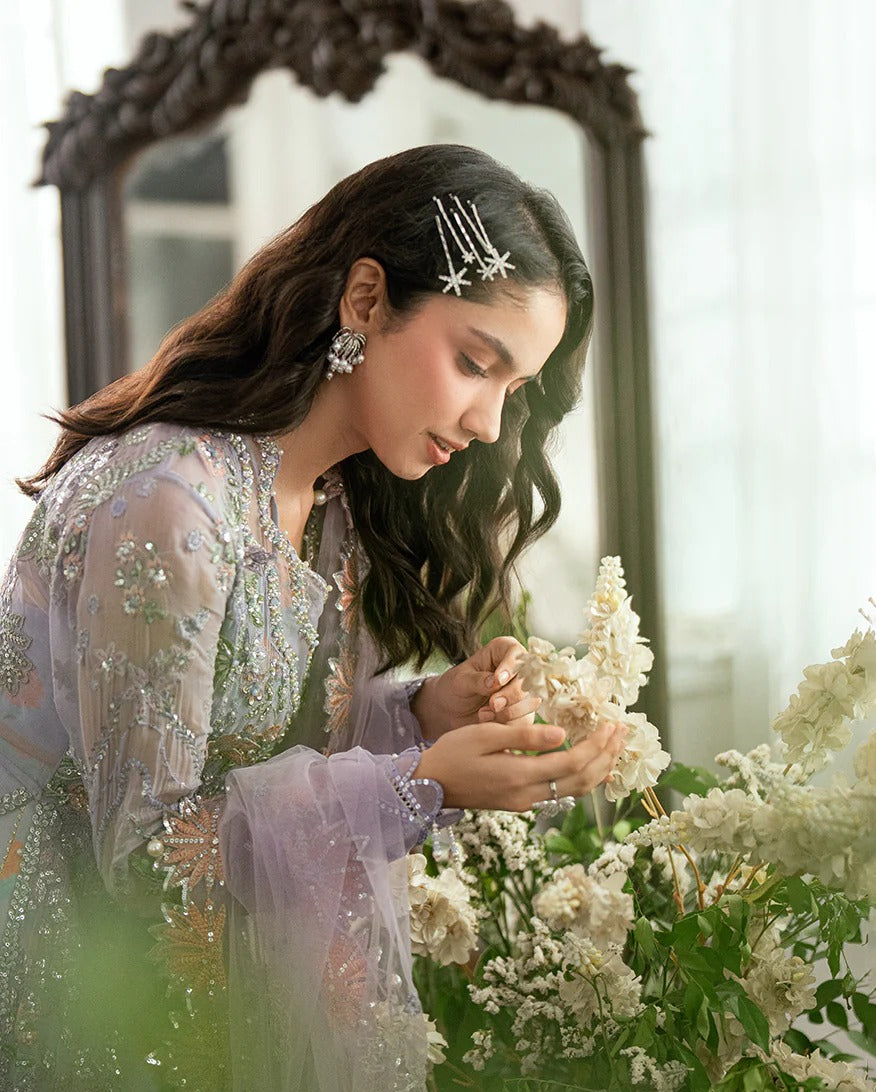 Shop this chiffon suit with hand embellishments, 3D florals, sequinned net dupatta & printed silk trouser. Includes tassels, lace & pearl detailing.