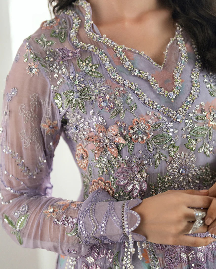 Shop this chiffon suit with hand embellishments, 3D florals, sequinned net dupatta & printed silk trouser. Includes tassels, lace & pearl detailing.