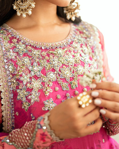Shop this shocking pink chiffon suit with silk sleeves, lurex dupatta & raw silk trouser. Hand embellishments, sequins & tassels add a luxe festive finish!