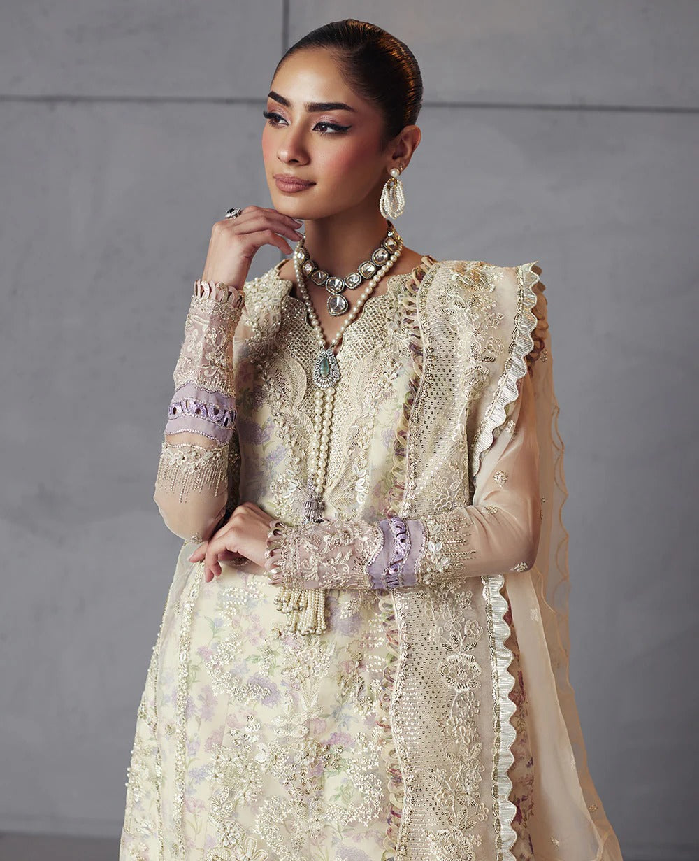 Edera exudes purity in white with hand-embellished organza panels, lilac-pink florals, and a scalloped embroidered dupatta — a vision of grace and artistry.